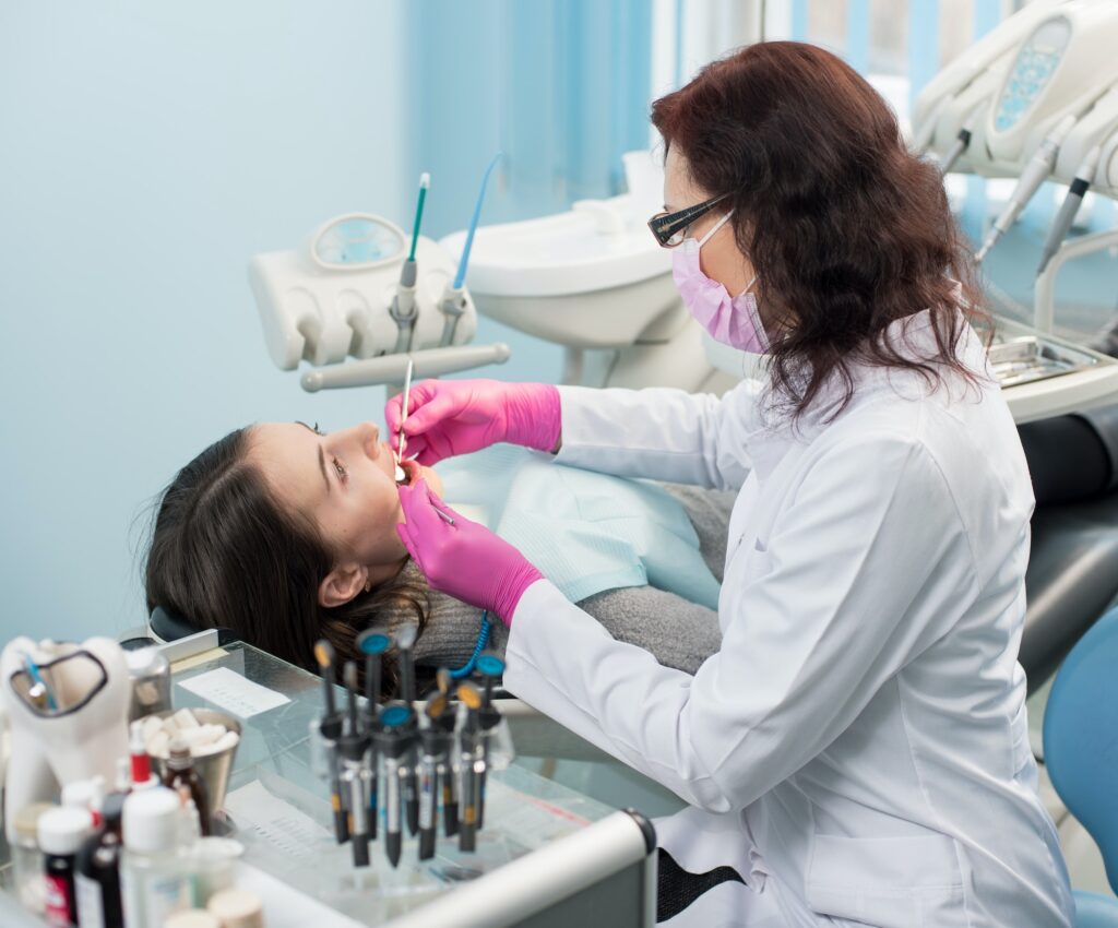 dentist with dental tools mirror and probe checking up patient teeth at dental clinic office 1